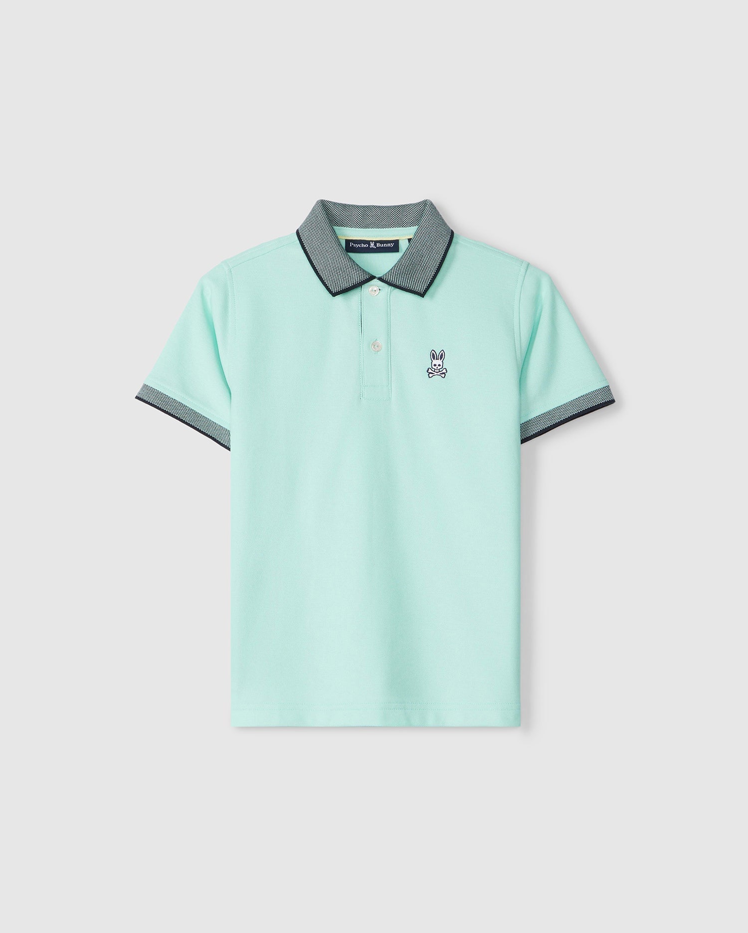 The Psycho Bunny KIDS SOUTHPORT PIQUE POLO SHIRT - B0K263B200 is a light mint green, short-sleeve polo shirt with a dark gray collar and sleeve cuffs. This Pima cotton polo showcases an embroidered bunny logo on the left chest, features a three-button placket, and is set against a plain white background.