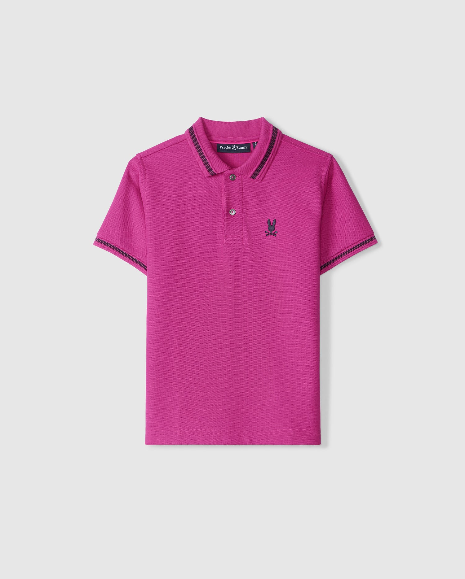 A bright pink KIDS RIVIERA PIQUE POLO SHIRT (B0K640C200) from Psycho Bunny, crafted from premium Pima cotton piqué with short sleeves. It highlights black embroidered detailing on the collar and sleeve edges, accompanied by a small embroidered Bunny logo on the left chest. The shirt is showcased against a plain white background.