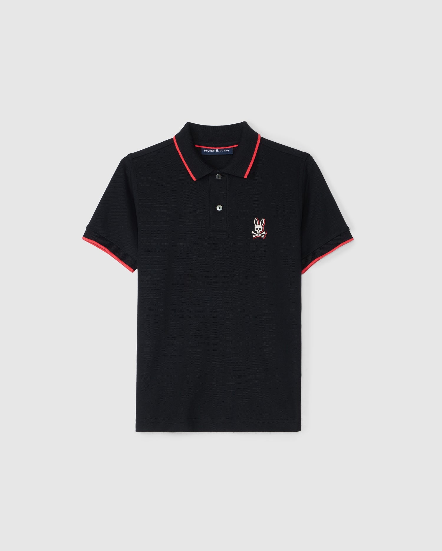 The KIDS KAYDEN PIQUE POLO - B0K675C200 from Psycho Bunny features a stylish black base with red trim on the collar and sleeve ends. Crafted from Pima cotton piqué, it boasts a white bunny logo on the left chest. The two-button placket adds both comfort and chic appeal, set against a plain white background.