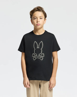 A young boy is wearing a KIDS MONARC FRONT BUNNY GRAPHIC TEE - B0U211E200 by Psycho Bunny, crafted from soft Pima Cotton. He has short, light brown hair and is standing against a plain, light gray background.