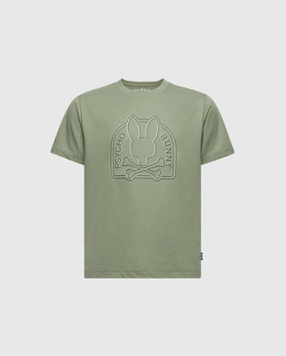 The KIDS MELBOURNE GRAPHIC TEE - B0U410F200 by Psycho Bunny in olive green features an embossed bunny with crossed bones and "Psycho Bunny" text. Made from soft Pima cotton, it has a round neckline and short sleeves for supreme comfort.