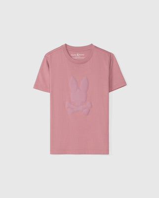 The KIDS KINGSTON GRAPHIC TEE - B0U743D200 by Psycho Bunny, made from soft Pima cotton jersey, is a pink shirt with a subtly embossed bunny graphic featuring a rabbit head above crossed bones, elegantly set against a plain white background.