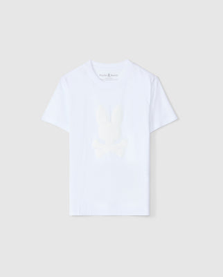 The KIDS KINGSTON GRAPHIC TEE - B0U743D200 by Psycho Bunny is a plain white T-shirt designed from a Pima cotton blend. It features a subtle center bunny graphic of a rabbit head and crossbones on the front, with a round neckline and short sleeves that complement the neutral light gray background.