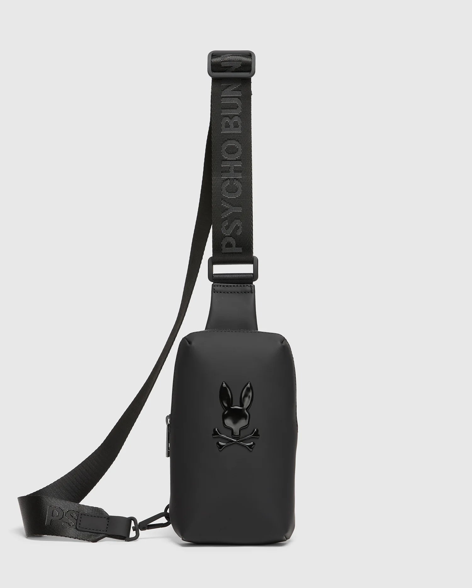 The MENS RUBBERIZED CROSSBODY - B6A635F200 by Psycho Bunny is a durable black polyester bag with an adjustable strap and bold 