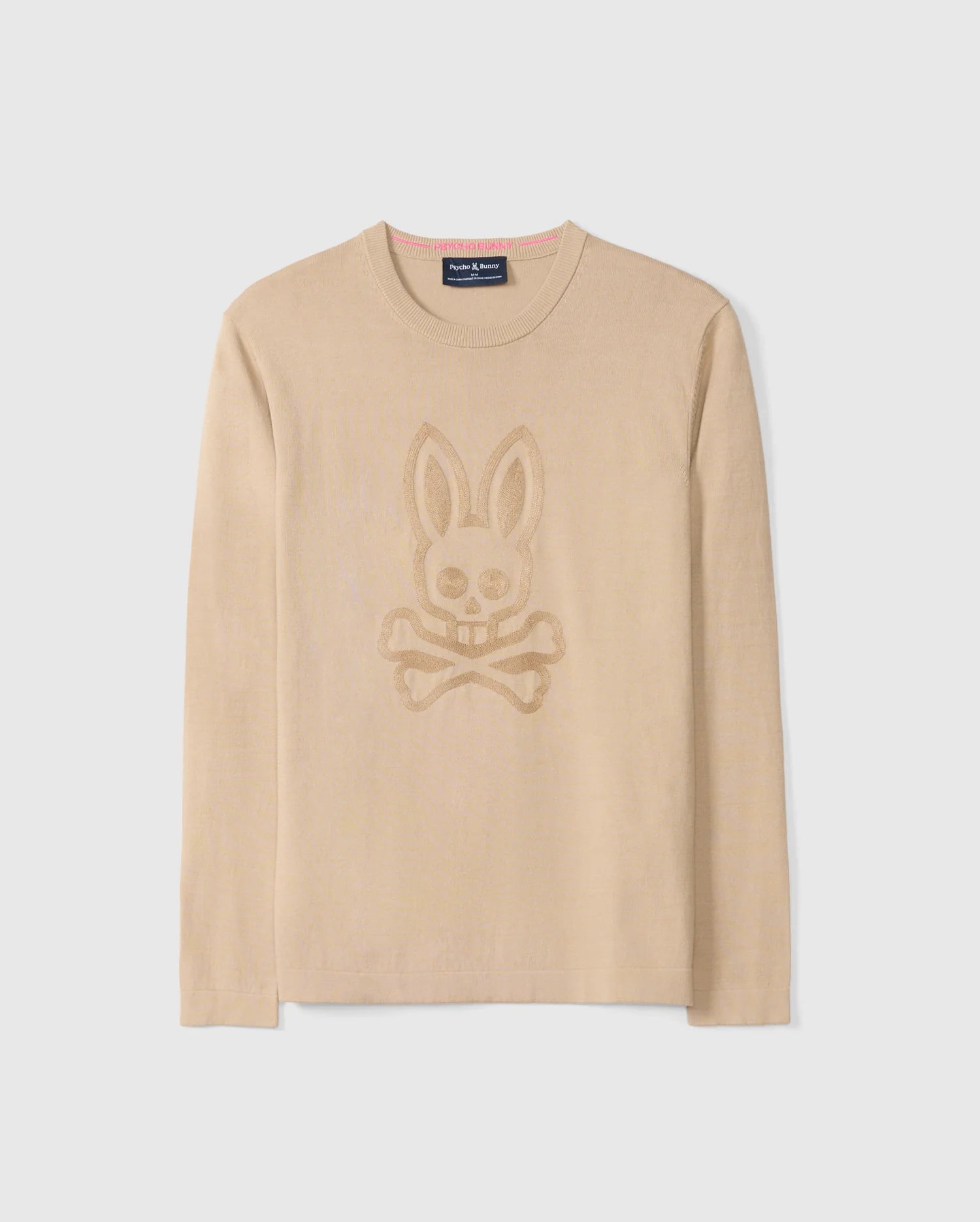 The MENS CORY CHAINSTITCH COTTON SWEATER - B6E893D200 by Psycho Bunny is a beige long-sleeve elegant cotton sweater featuring a chainstitch embroidery design of a bunny skull and crossbones centered on the front. The neckline, cuffs, and hem are ribbed, with a small, dark rectangular brand tag attached near the inside collar. The background is white.