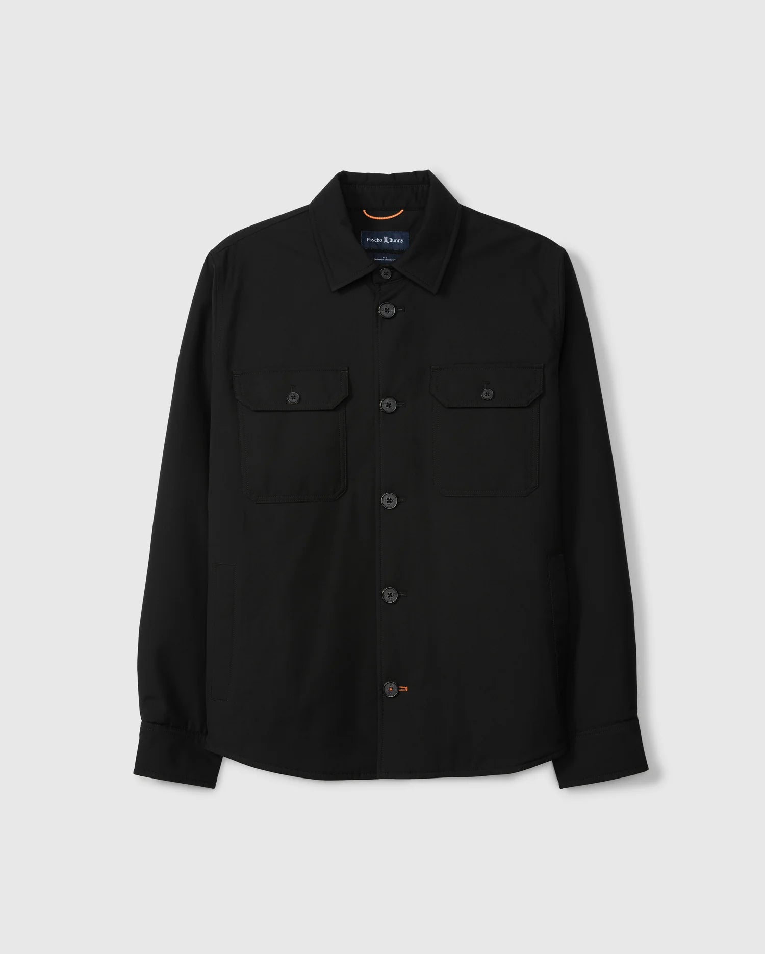 The MENS HILLCREST PADDED SHACKET - B6J936D200 by Psycho Bunny is displayed against a plain white background. This black long-sleeve shirt features buttoned cuffs, patch pockets with button-secured flaps, and a pointed collar. It has a casual, yet structured design.