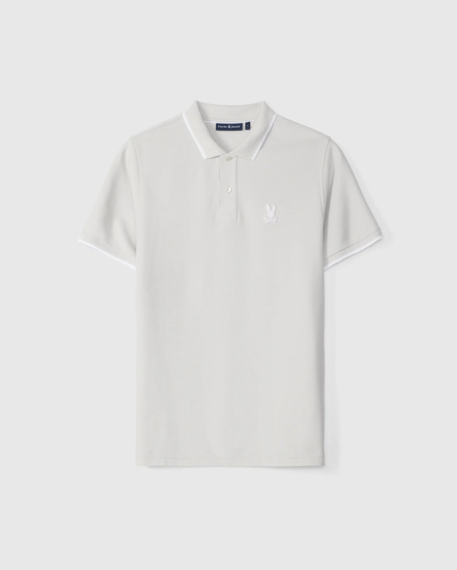 A plain white Pima cotton polo shirt with short sleeves, featuring a collar and mother-of-pearl buttons on the placket. There is an embroidered Bunny design on the left chest area. The MENS HOUSTON PIQUE POLO SHIRT - B6K604C200 by Psycho Bunny has a simple and clean design.