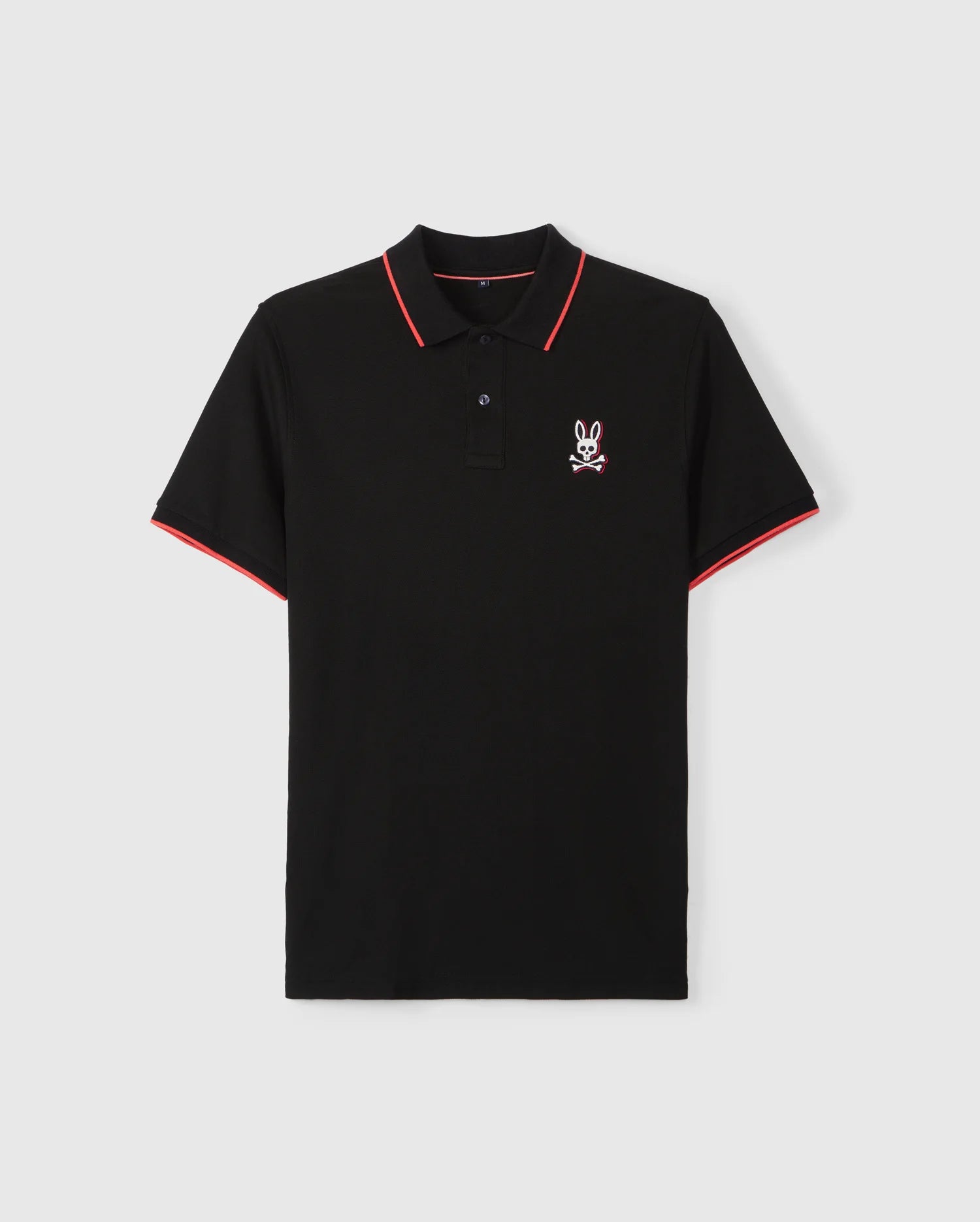 A MENS KAYDEN PIQUE POLO - B6K675C200 by Psycho Bunny with short sleeves, featuring red trim around the collar and striped cuffs. Made from Pima cotton piqué, the shirt boasts a small white and red embroidered Bunny logo on the left chest.