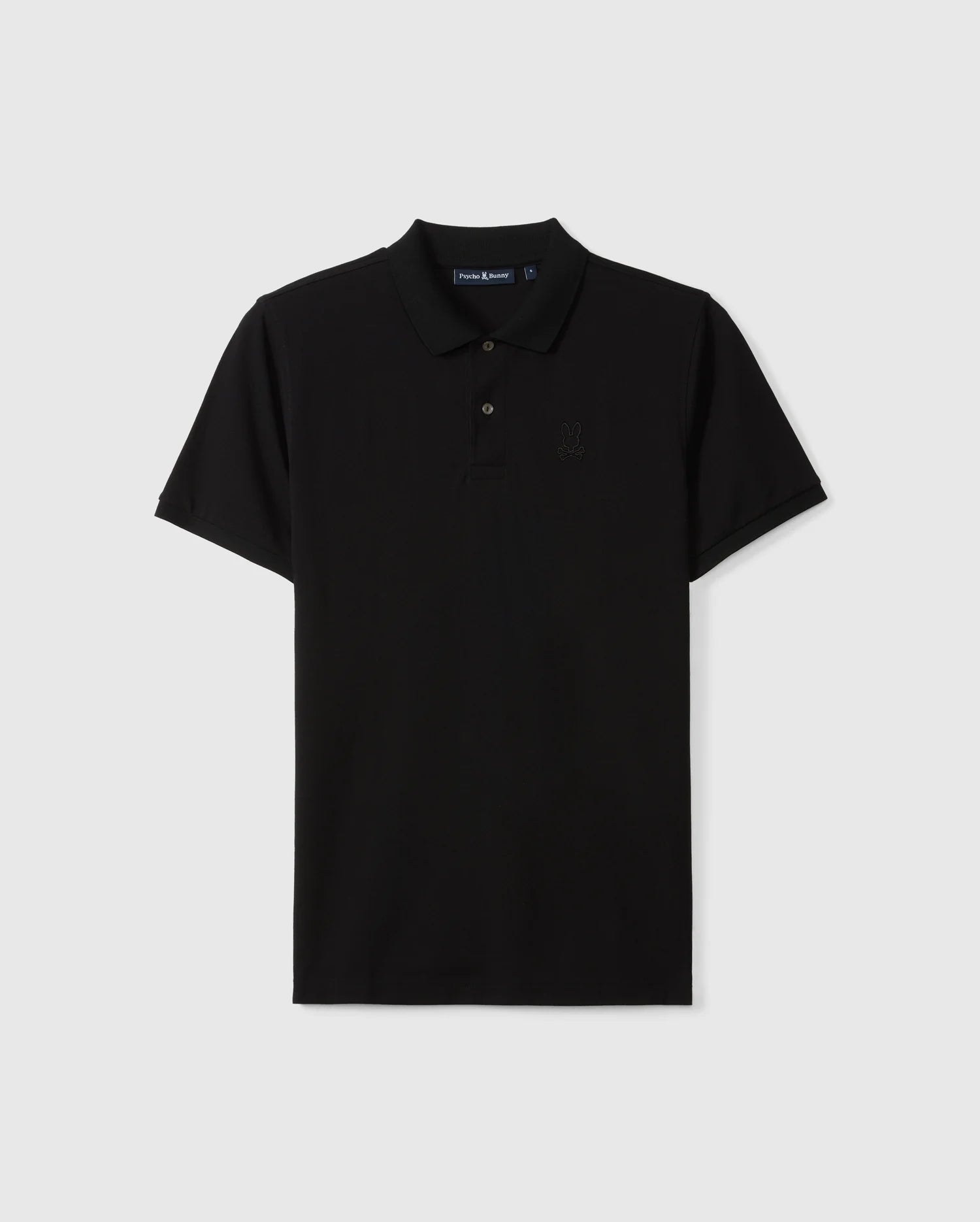 The Psycho Bunny Men's James Premium Pique Polo Shirt (B6K945D200) is a black short-sleeved polo made from soft Pima cotton, featuring a collar and button placket. It has a subtle embroidered logo on the left chest area, making it a durable shirt option. The background is plain and light gray.