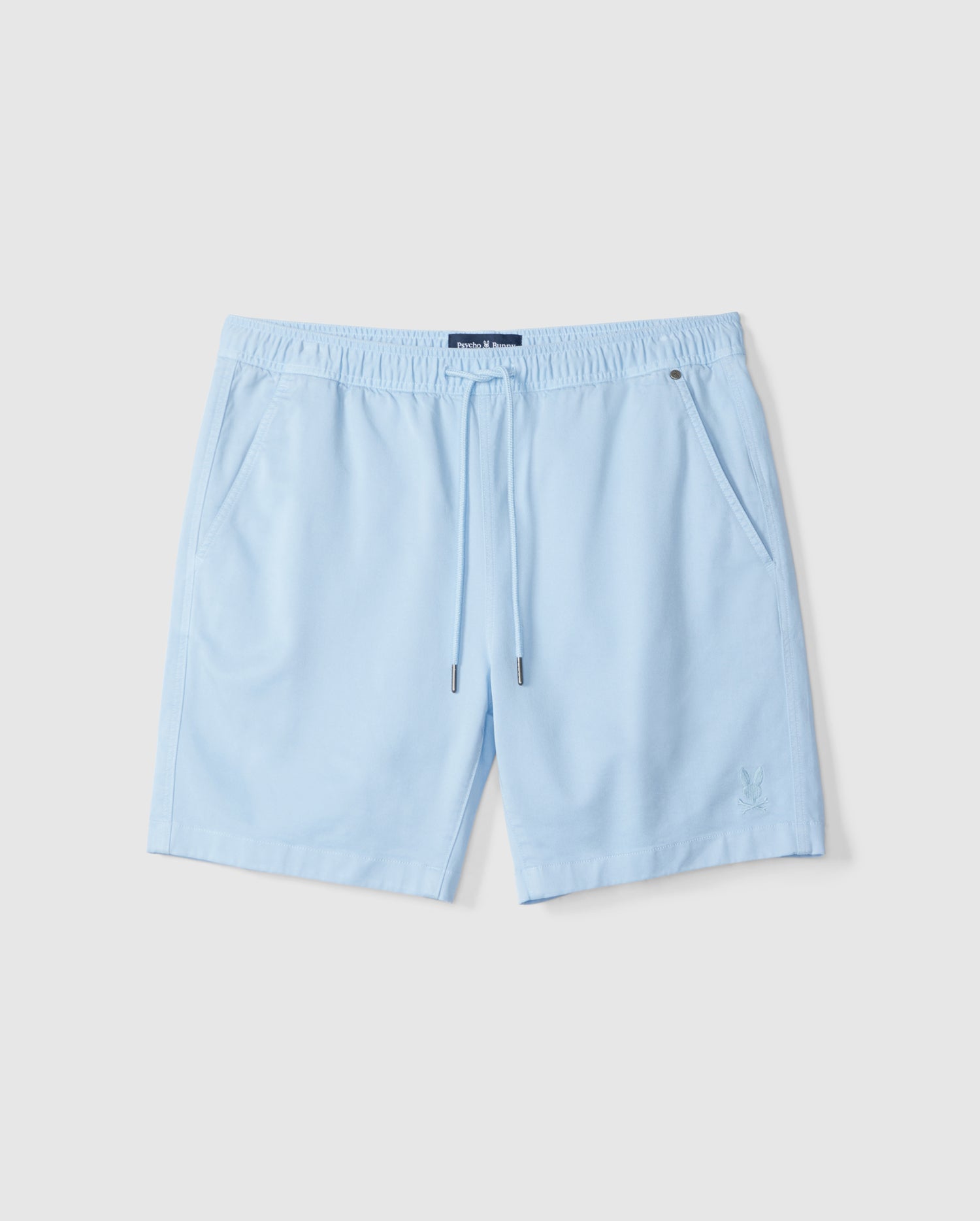 Light blue swim shorts with an elastic waistband and drawstring, displayed on a plain white background. The Psycho Bunny MENS WILLIS STRETCH TENCEL SHORT - B6R239Y1WB feature a small embroidered logo on the left leg.