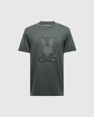 The Psycho Bunny MENS PIERCE EMBROIDERED GRAPHIC TEE - B6U115E200, in dark green, is made from soft Pima cotton and boasts a bold design featuring a large, stylized bunny head above crossed bones in the center, enhanced with intricate embroidery for added texture.