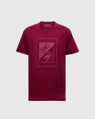 A maroon MENS DOTSER GRAPHIC TEE - B6U197E200 by Psycho Bunny featuring a rectangular graphic with abstract shapes, such as scissors and a rabbit head, crafted from premium Peruvian Pima Cotton. The shirt is presented against a plain light gray background.