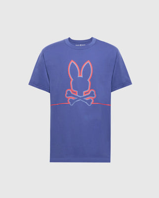 The Psycho Bunny MENS DACANO FRONT GRAPHIC TEE - B6U314E200 is a blue t-shirt with a whimsical bunny silhouette in bright red above crossed bones, creating a playful skull and crossbones design. This comfort-forward crew neck tee offers short sleeves and a regular fit, ideal for everyday wear.