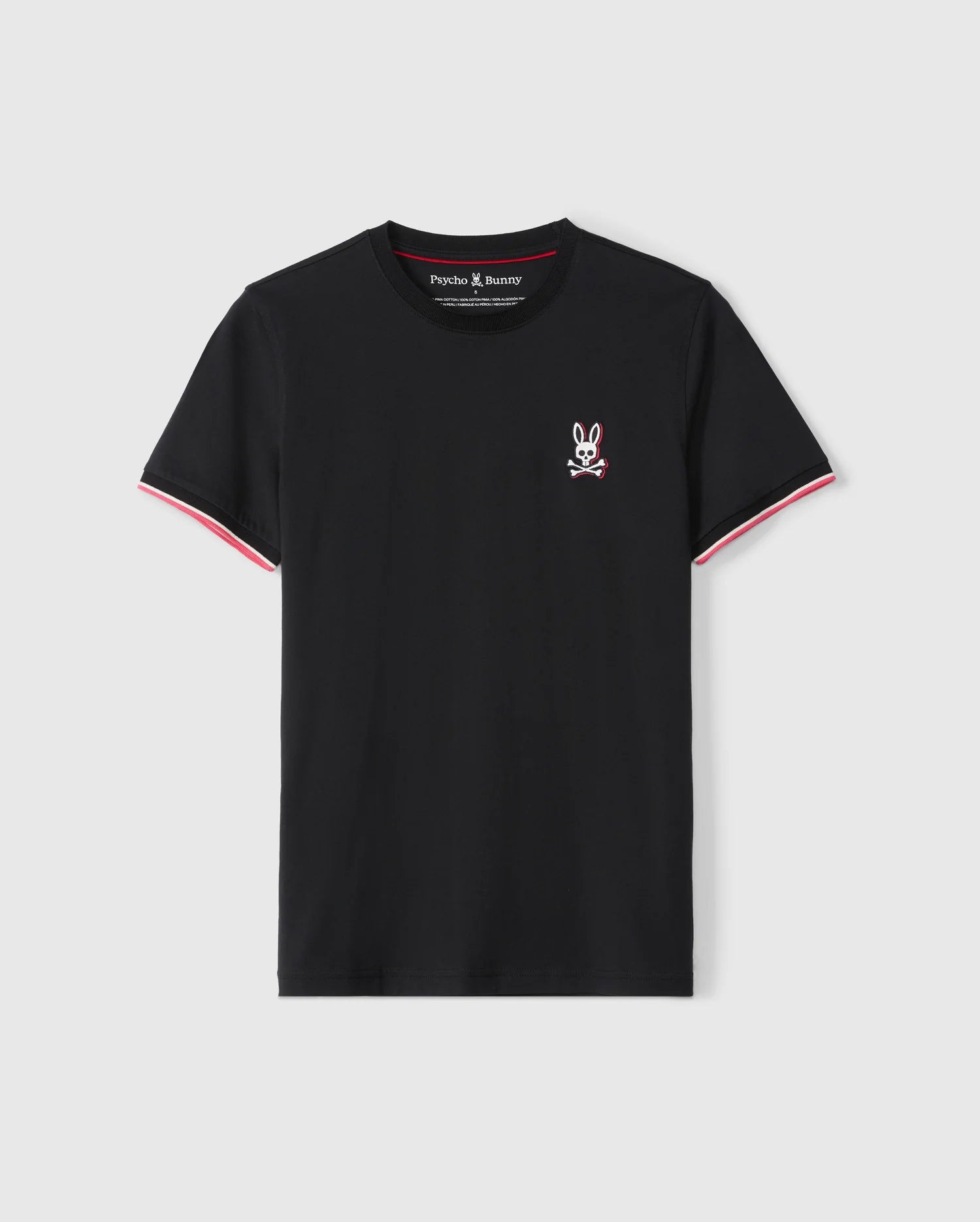 The MENS KAYDEN FASHION TEE - B6U577C200 by Psycho Bunny is a black Pima cotton short-sleeve tee featuring a small white and red embroidered cartoon rabbit head with crossbones on the left chest. The sleeves are accented with red and white trim along the cuffs, and the brand name 