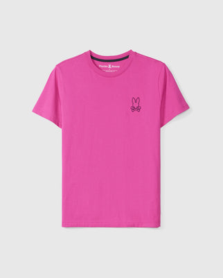 The MENS PEARLAND BACK GRAPHIC TEE - B6U632C200 from Psycho Bunny is a vibrant pink shirt featuring a small, black embroidered logo on the left chest. The logo consists of a bunny with crossbones underneath, adding a varsity aesthetic. Made from premium Pima cotton, this T-shirt has a round neckline and short sleeves, with an interior tag that reads "Psycho Bunny.