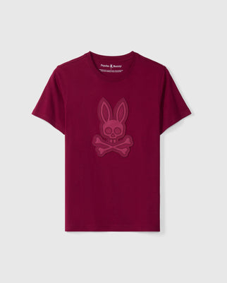 The MENS MALTON GRAPHIC TEE - B6U795D200 by Psycho Bunny presents a stylish maroon design crafted from soft Pima cotton. It showcases a subtly embossed skull and crossbones with bunny ears on the front, elegantly set against a plain grey background to merge timeless design with modern flair.