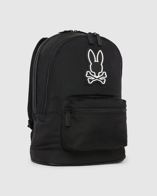 Introducing the DOME BACKPACK - B6A628Z1BP by Psycho Bunny, a black urban backpack showcasing the signature white bunny and crossbones logo on its front pocket. It offers multiple compartments, including a padded laptop compartment, with convenient zippers for easy access, making it ideal for daily use or travel.